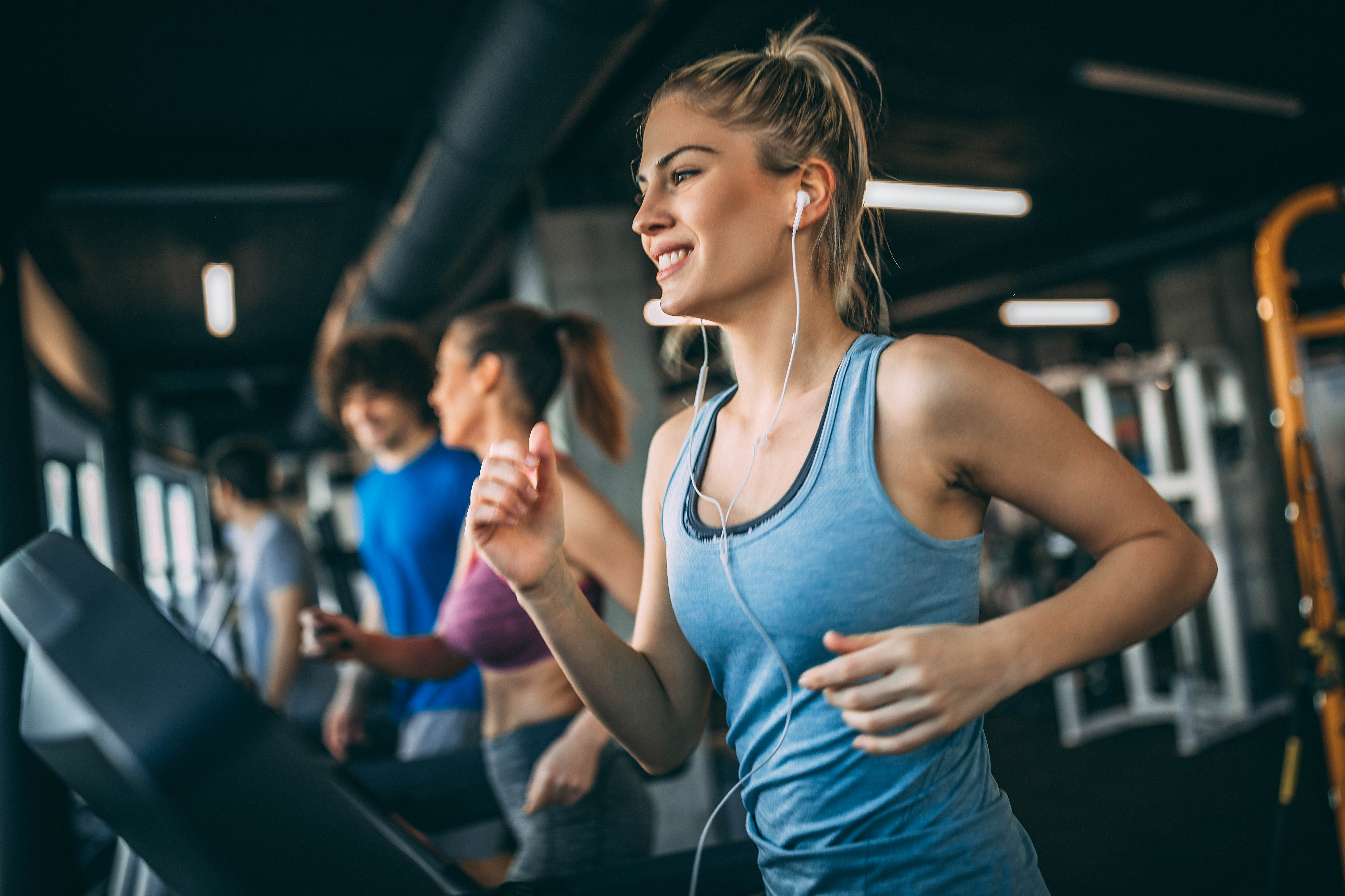 Young blonde woman running on a treadmill in a gym Young blonde woman running on a treadmill in a gym